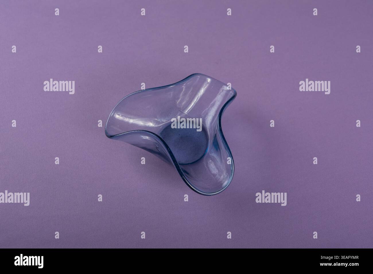 Still life featuring a delicate blue glass bowl against a pale purple background. Soft light emphasizes textures, ideal for designs and visuals relate Stock Photo