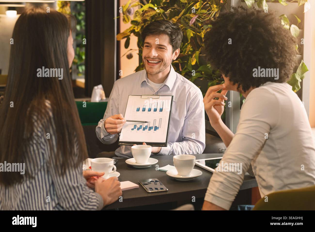 Managers analyzing chart at a business lunch Stock Photo