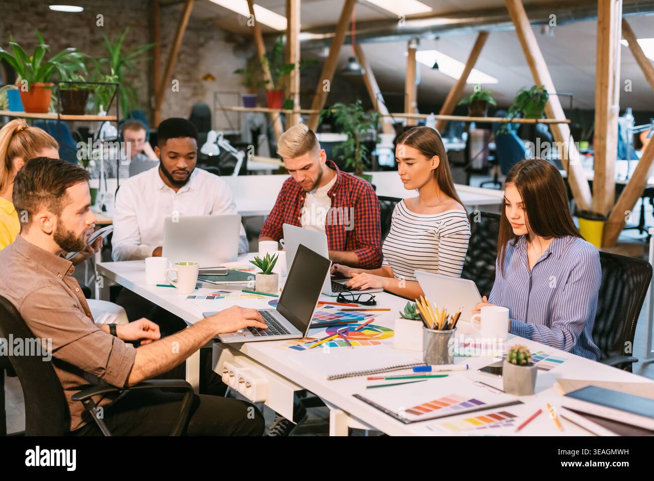 Diverse Team Collaborating in a Modern Workspace on Creative Project Ideas Stock Photo
