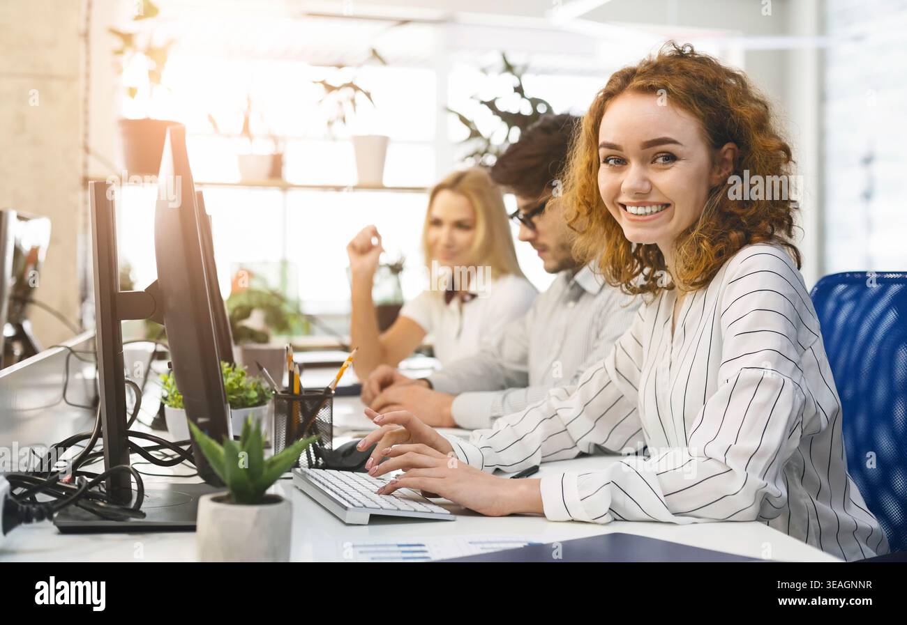 Team Members Collaborate in a Modern Office Setting While Working on Computers During the Afternoon Stock Photo