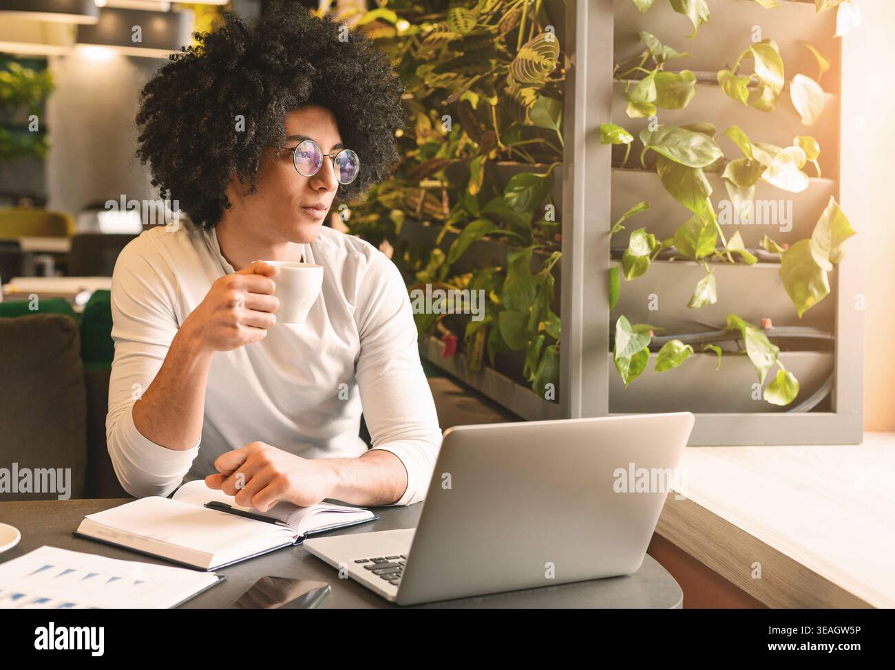 Handsome young man working on laptop and smiling Stock Photo