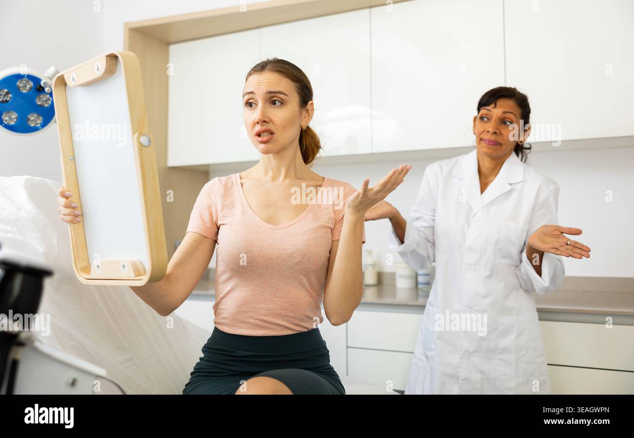 Dissatisfied woman checking result after cosmetology procedure Stock Photo