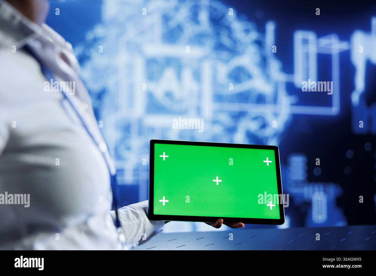 Admin uses green screen tablet to develop artificial intelligence neural networks nodes modeled after human brain. Worker setting up AI machine learning using chrome key device Stock Photo