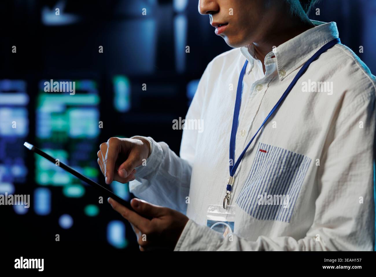 Meticulous programmer between server units providing processing resources for companies worldwide. Seasoned developer fixes high tech workplace supercomputers used for storing large databases Stock Photo