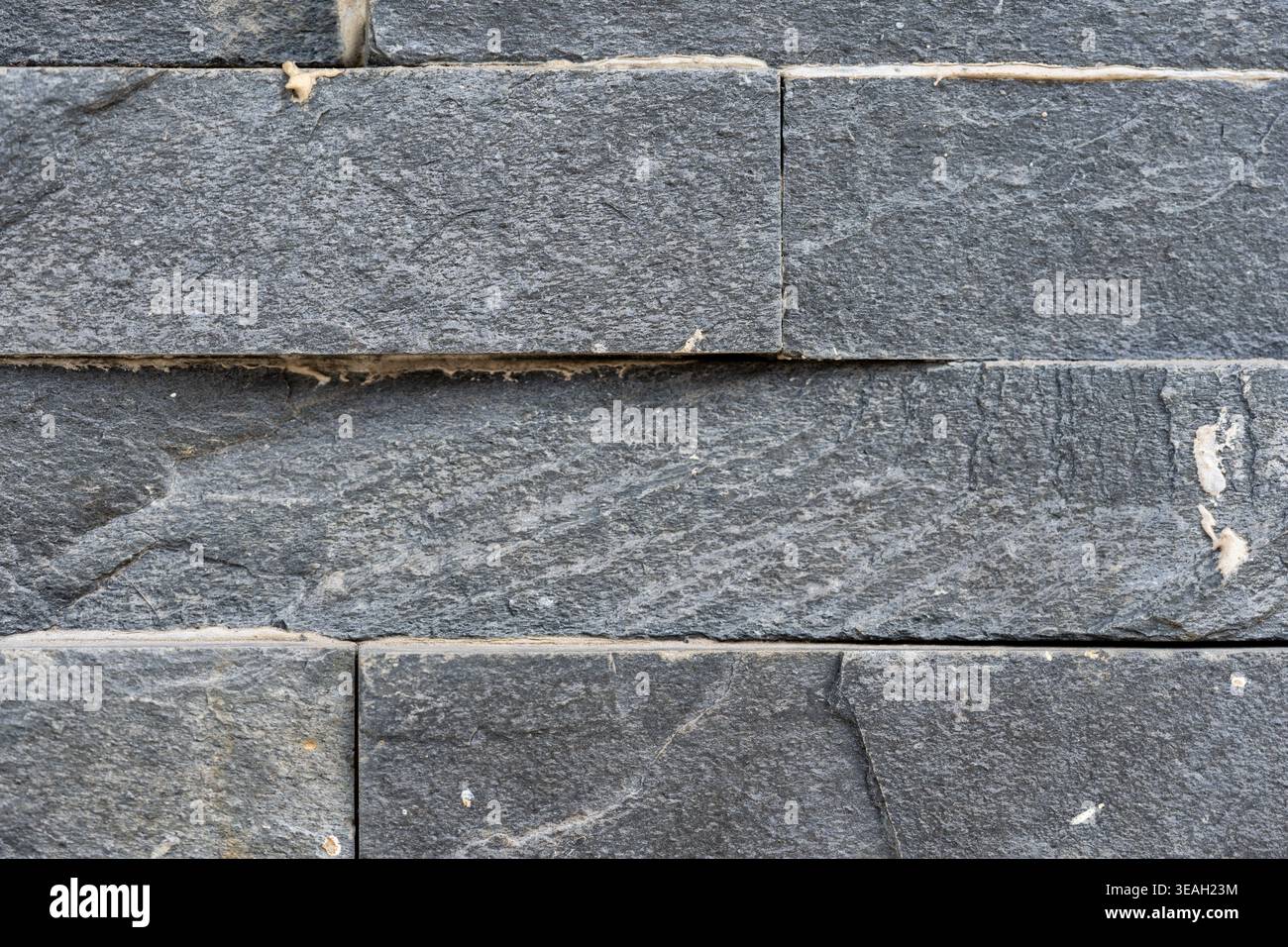 Stacked Dark Gray Slate Stone Wall Cladding Texture with Rough Natural Surface Stock Photo