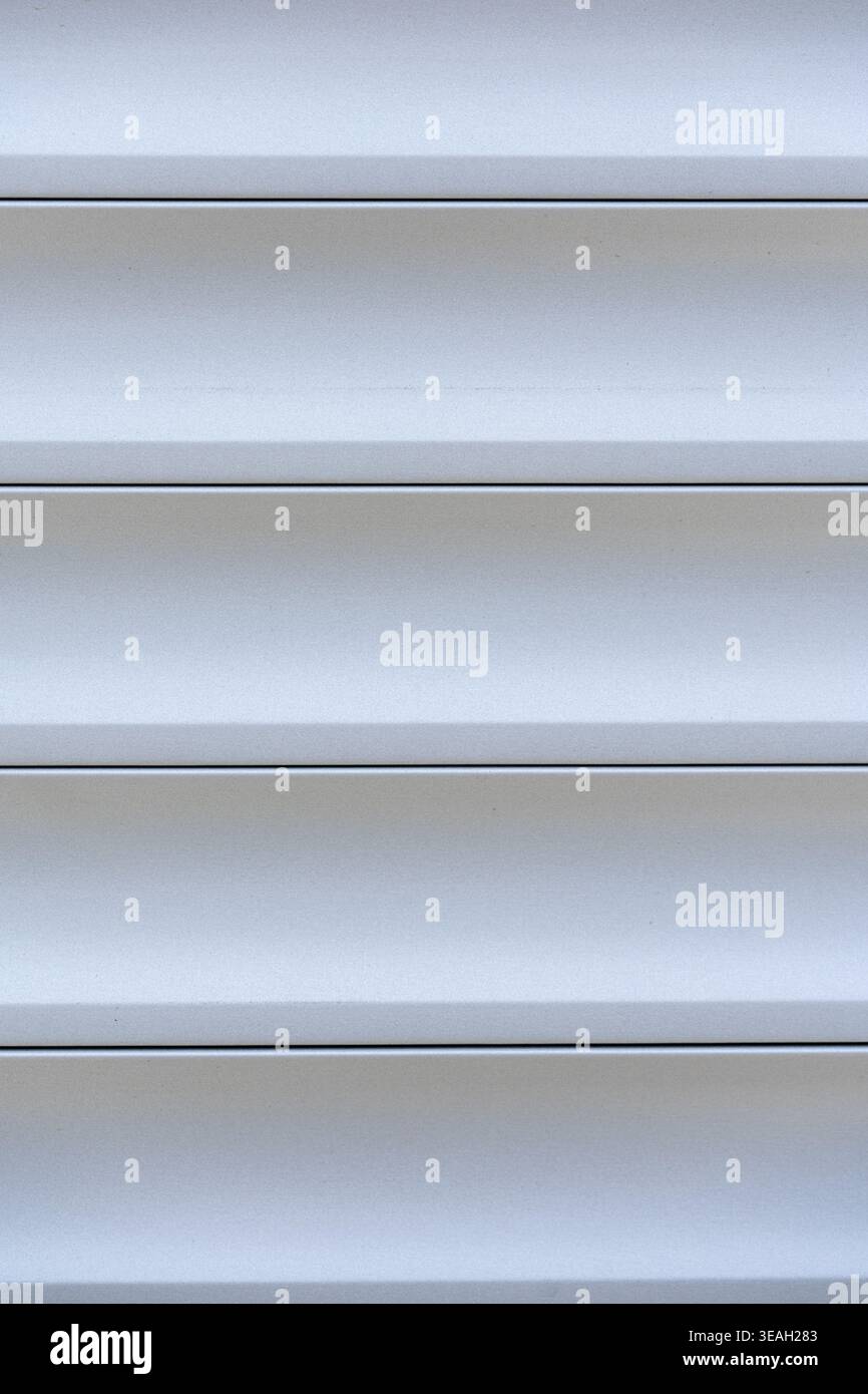 Close-up of Clean Vinyl or Aluminum Siding Texture with Smooth, Even Surface, Monochromatic Background of Light Gray Horizontal Panels and Grooves for Stock Photo