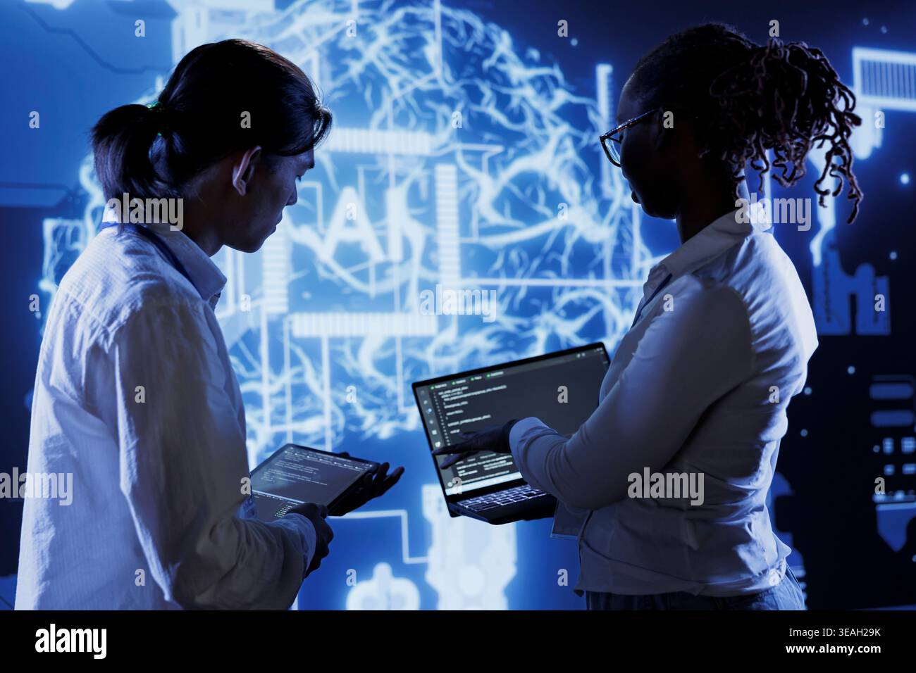 Trained programmers brainstorm ways to use AI cognitive computing to extract usable information from complex data. Adept employees implement artificial intelligence to process massive datasets Stock Photo
