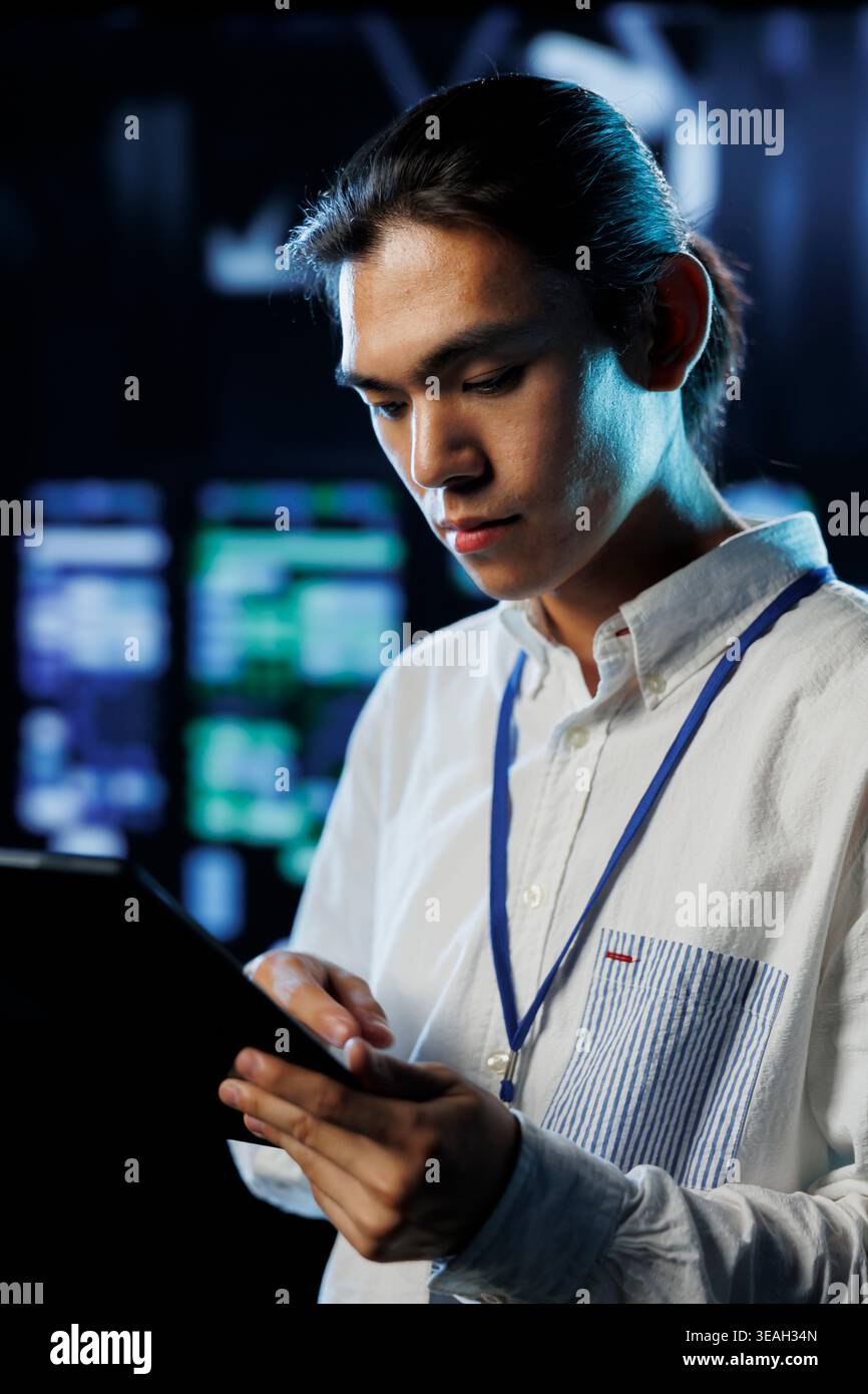 Tech support worker between server room hardware providing processing resources for companies worldwide. Skillful developer fixes data center supercomputers used for storing large databases Stock Photo