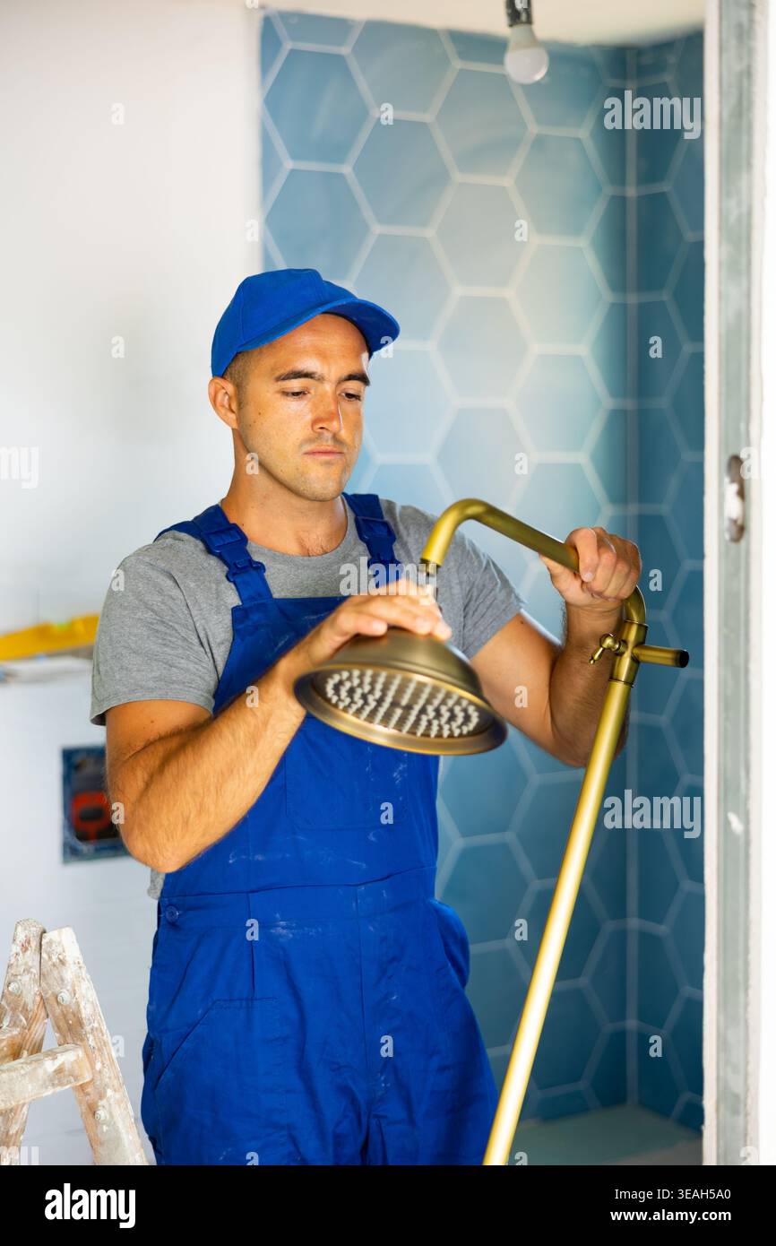 Plumbing specialist assembling tubes of shower in bathroom Stock Photo