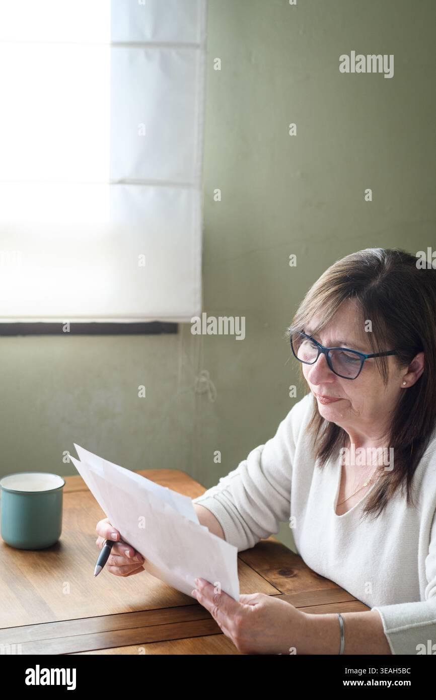 Senior woman reading documents at home Stock Photo