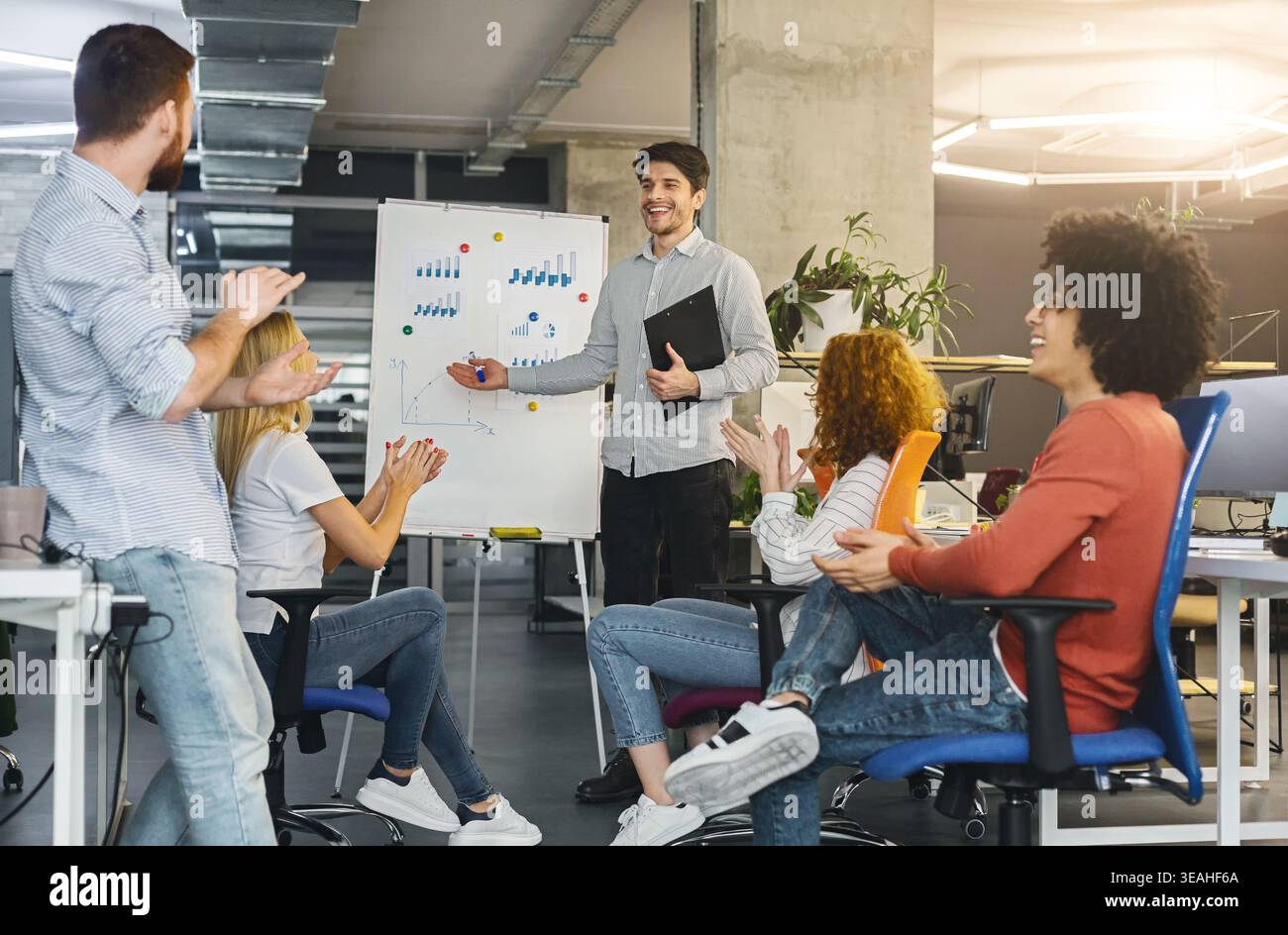 Young millennial team analyzing information on graphs and charts Stock Photo