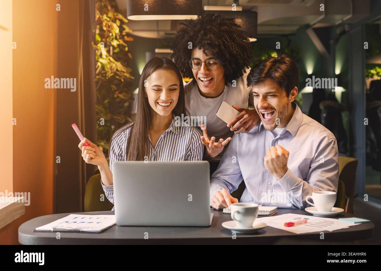 Successful business team looking at laptop happily Stock Photo