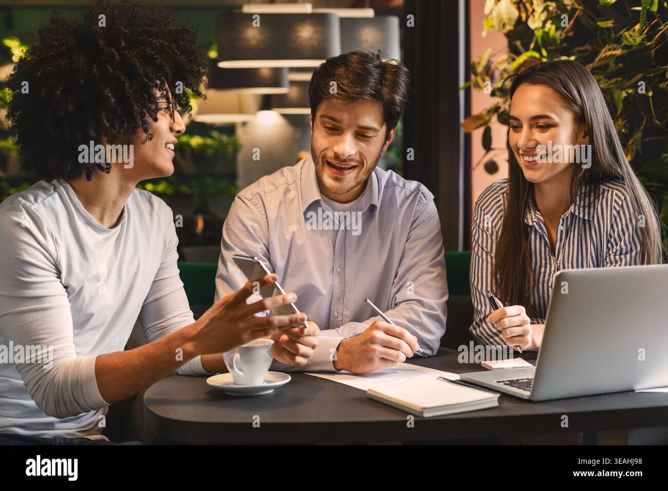Young man sharing creative ideas with colleagues Stock Photo