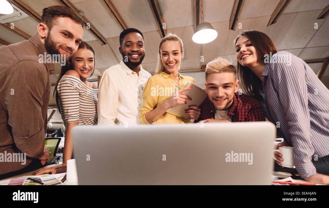 Software developers discussing new project, looking at laptop Stock Photo