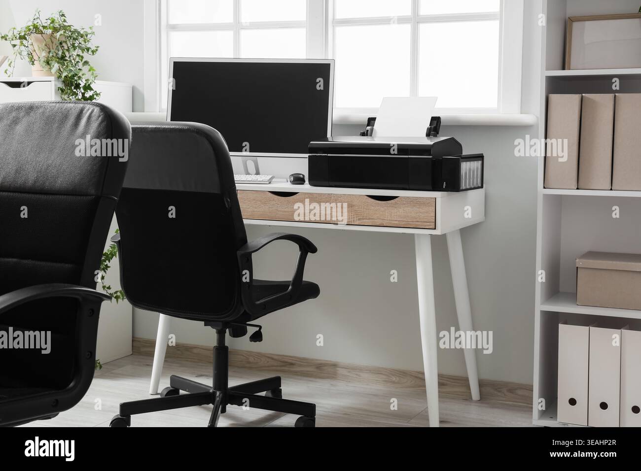 Modern workplace with computer and printer near window in office Stock Photo