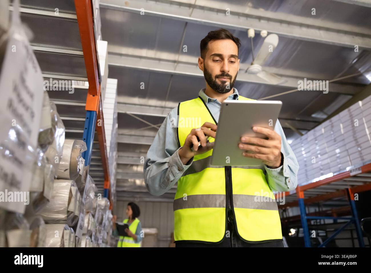 Hispanic male worker using digital tablet in warehouse Stock Photo
