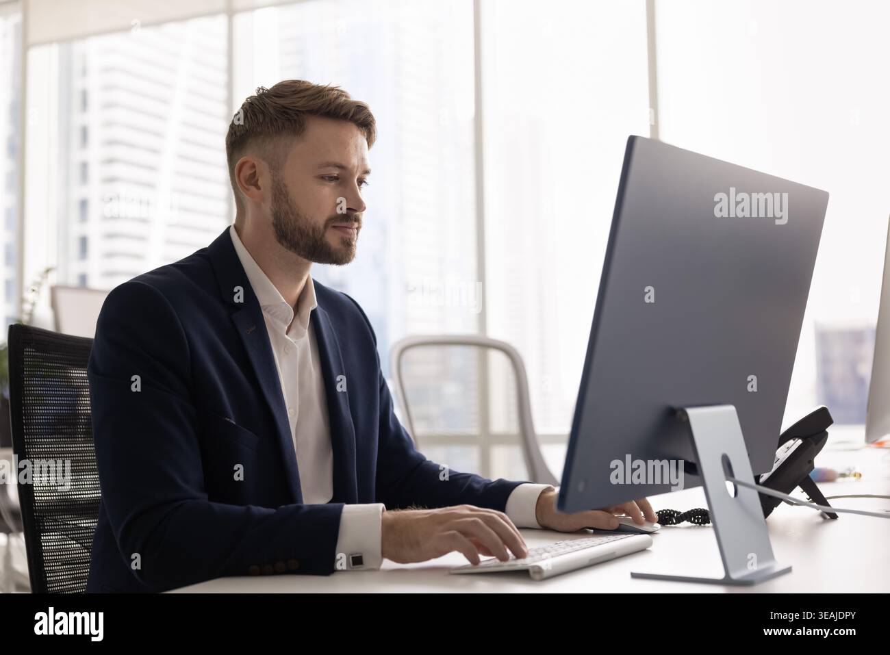 Businessman working on desktop computer in modern office Stock Photo