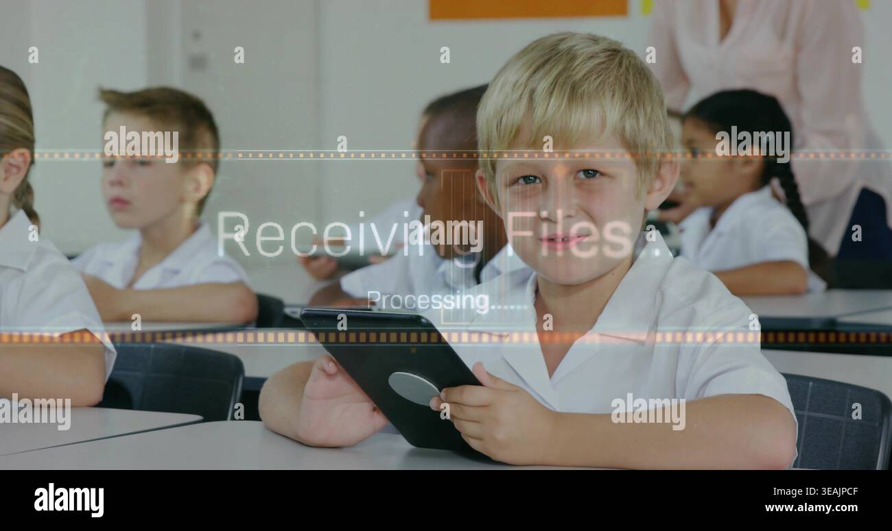Using tablet front boy doing digital task in class in white collared shirt receiving files overlay Stock Photo