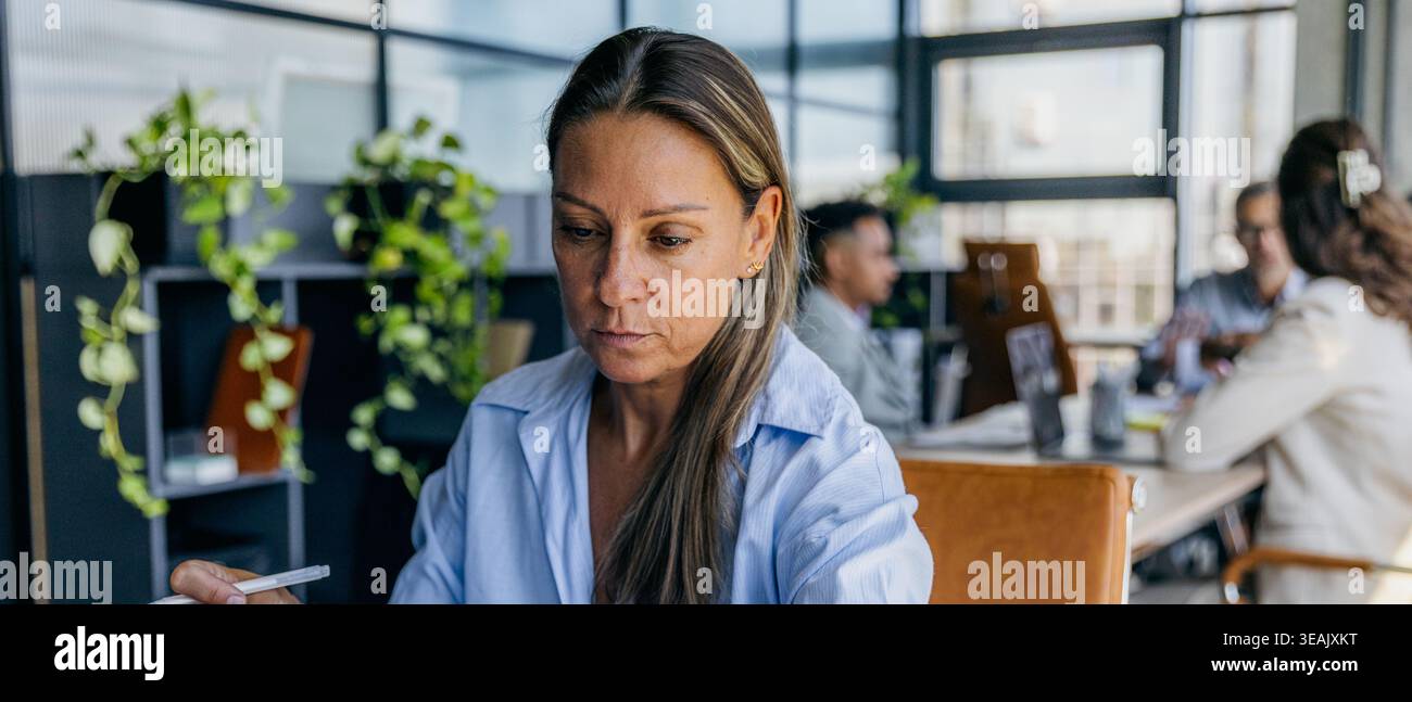 Businesswoman analyzing timeline amidst team collaboration Stock Photo