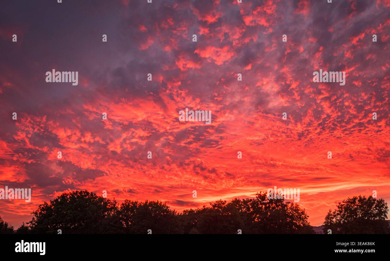 Fiery red clouds painting dramatic sunset sky Stock Photo
