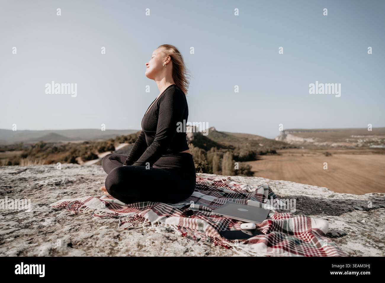 Woman Meditating on a Mountaintop Stock Photo