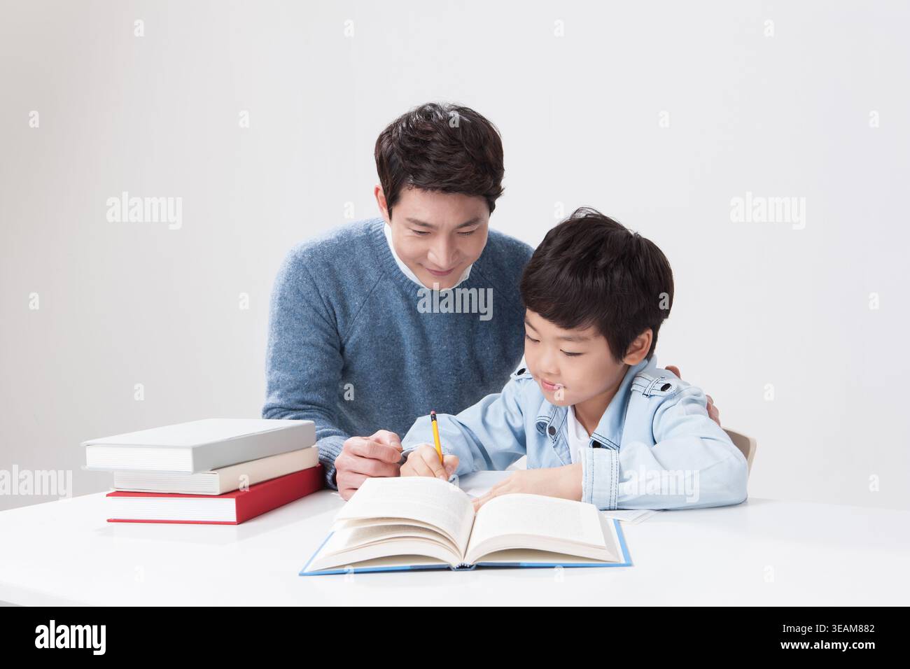 a father helping his son with homework Stock Photo
