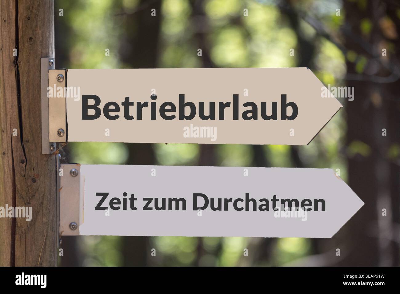 (Photo montage) Signs in the forest with the added text BETRIEBSURLAUB and ZEIT ZUM DURCHATMEN Stock Photo