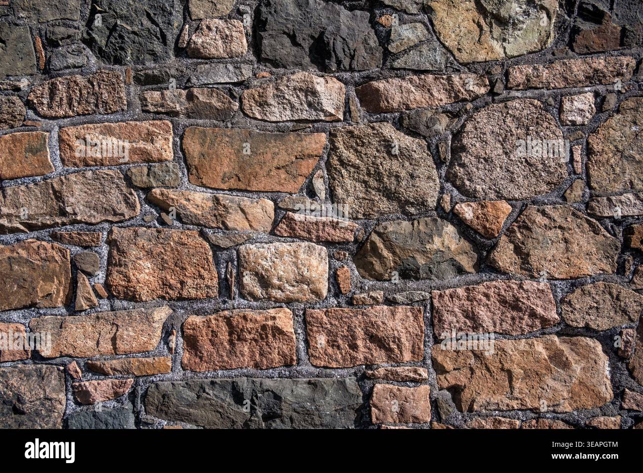 Rough granite stone wall for use as a background texture Stock Photo