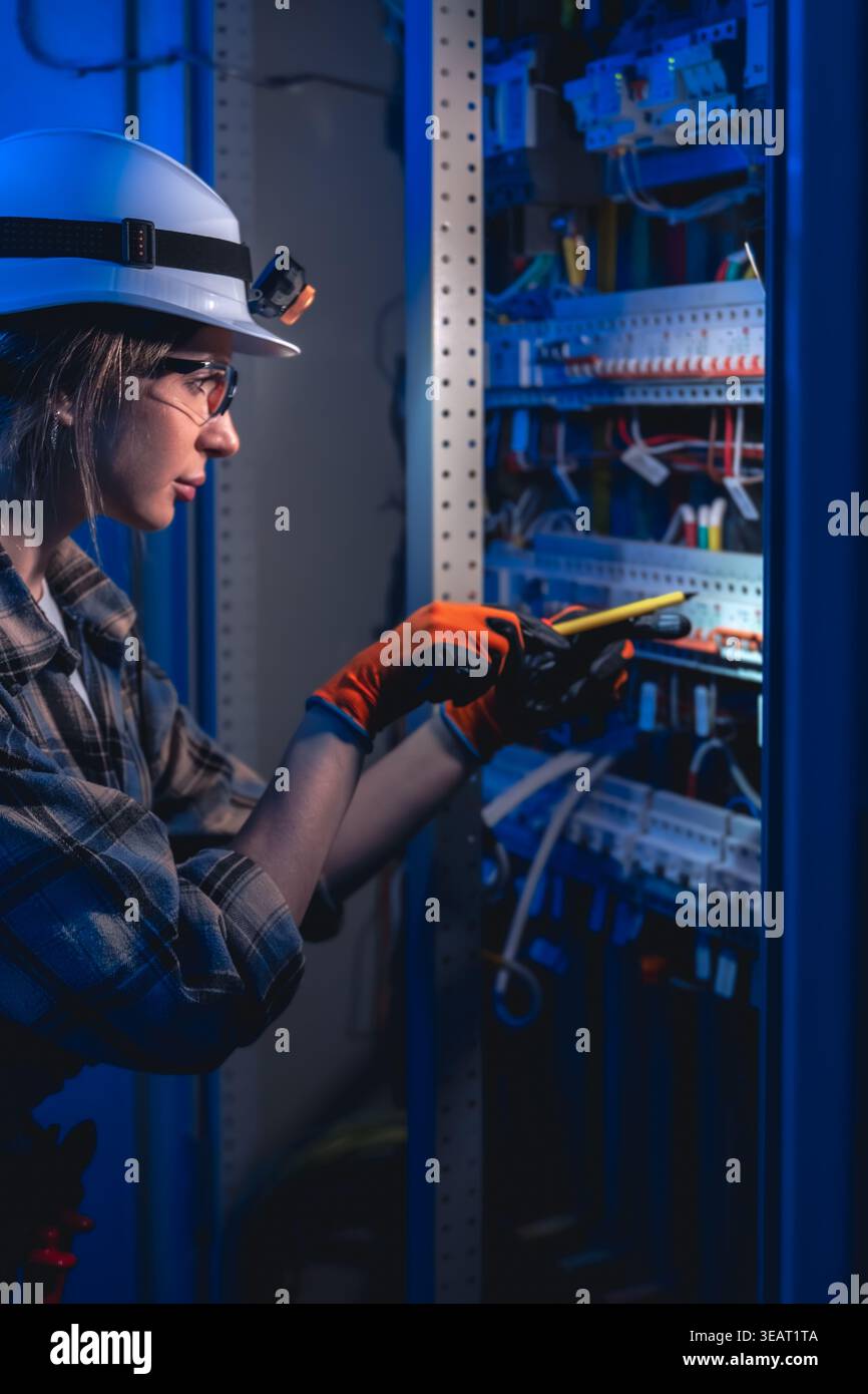 Electrician testing electrical panel with voltage tester. Industrial maintenance. Stock Photo
