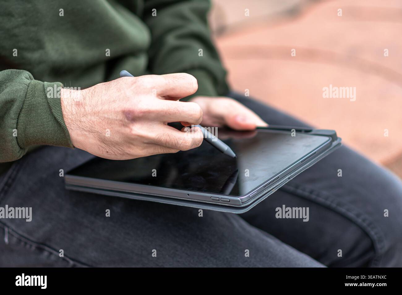 Person using a stylus on tablet screen Stock Photo