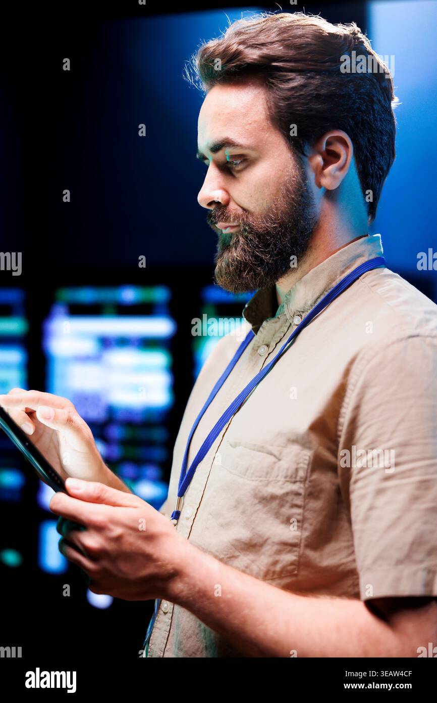 Cloud computing business executive imputing audit data in server room supporting AI through high performance computing. Skillful expert making sure supercomputers are operating flawlessly Stock Photo
