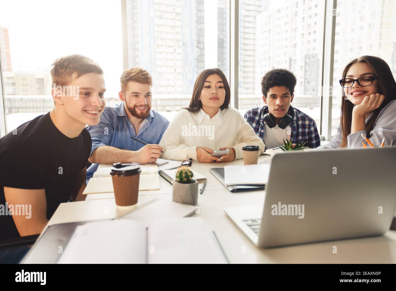 Skilled young programmers watching webinar on laptop computer Stock Photo