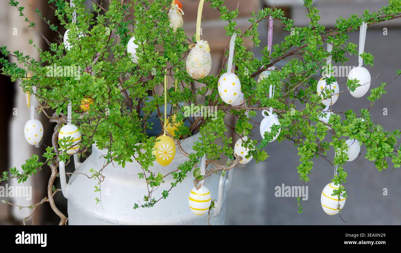 Rustic Easter Decoration Featuring Hanging Eggs and Green Branches Stock Photo