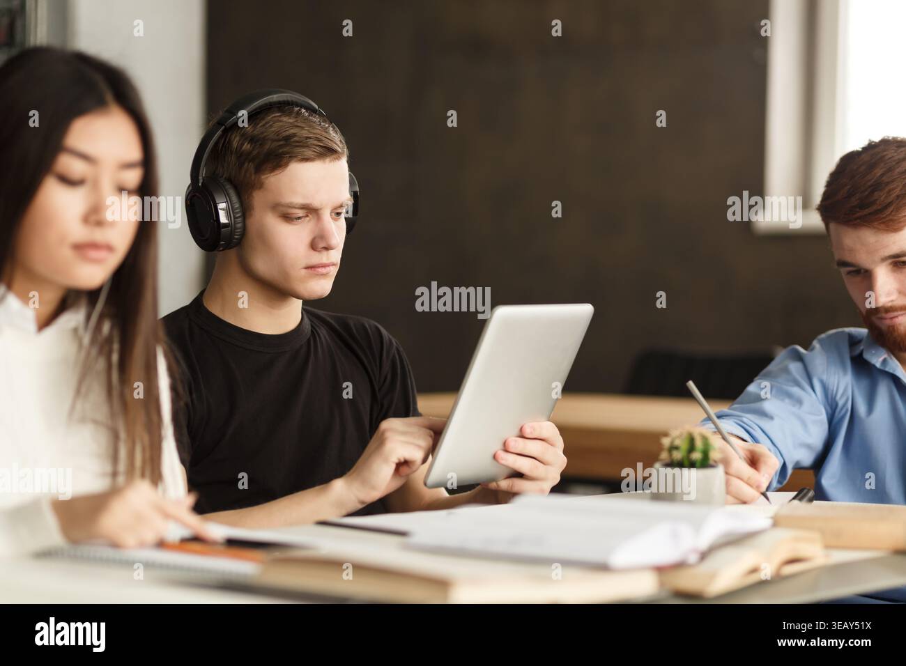 College student surfing internet on tablet in library Stock Photo