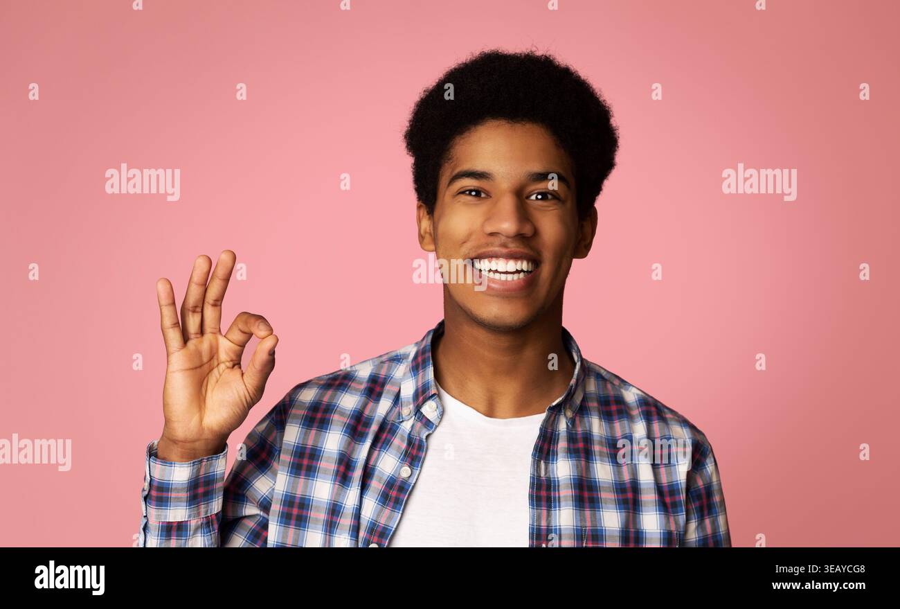 Happy Afro Guy Gesturing OK Sign and Smiling Stock Photo