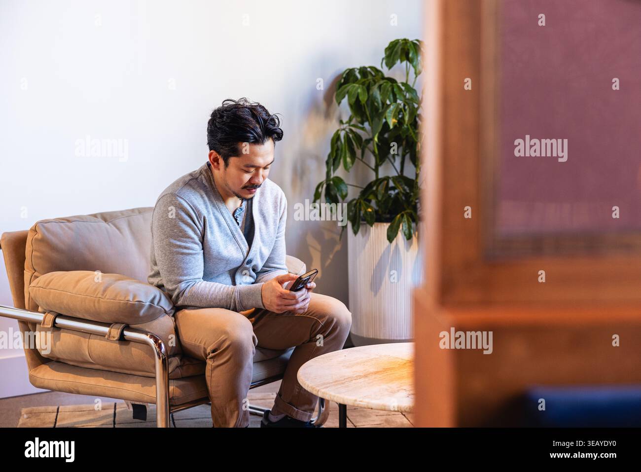 Casual Businessman using a smartphone in office Stock Photo