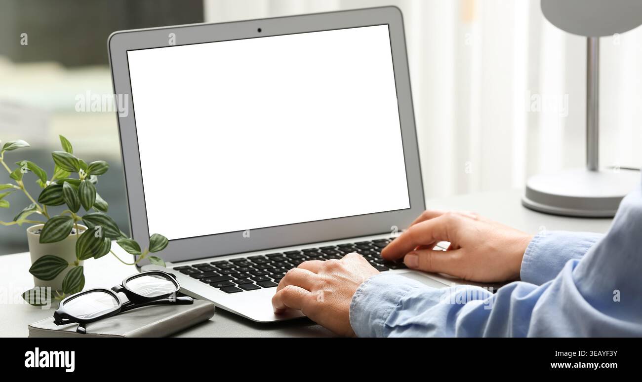 Young female programmer using laptop in office, closeup Stock Photo