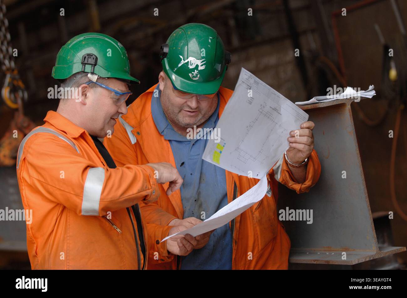 Engineers consulting plans, blueprints and schematics. Stock Photo