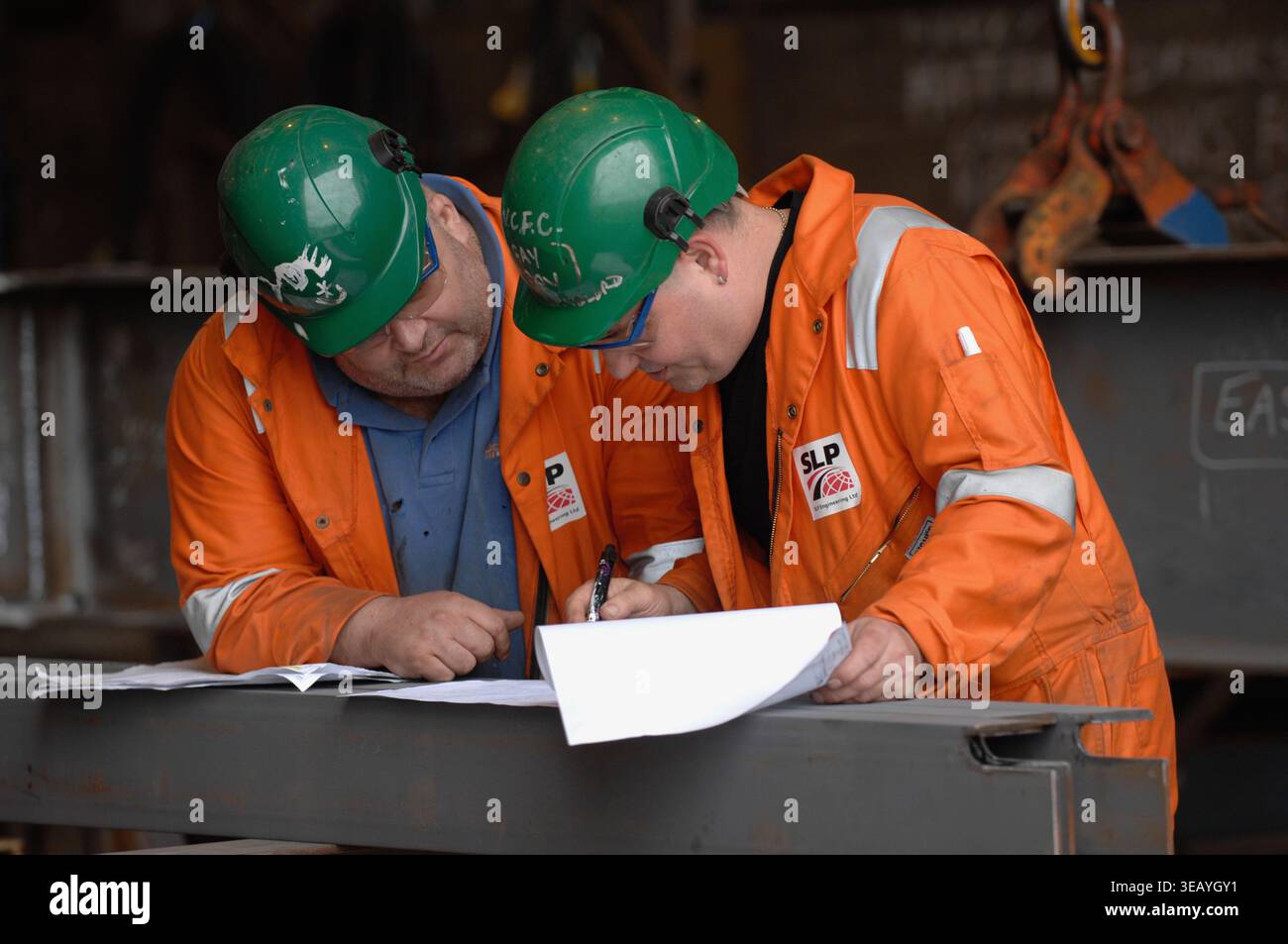 Engineers consulting plans, blueprints and schematics. Stock Photo