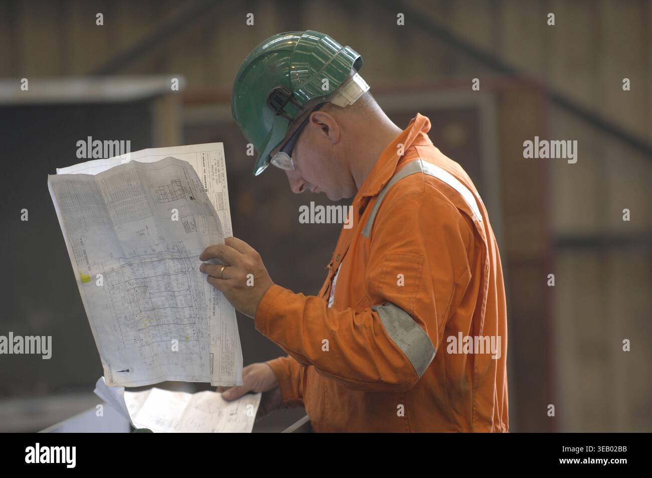 Engineers consulting plans, blueprints and schematics. Stock Photo