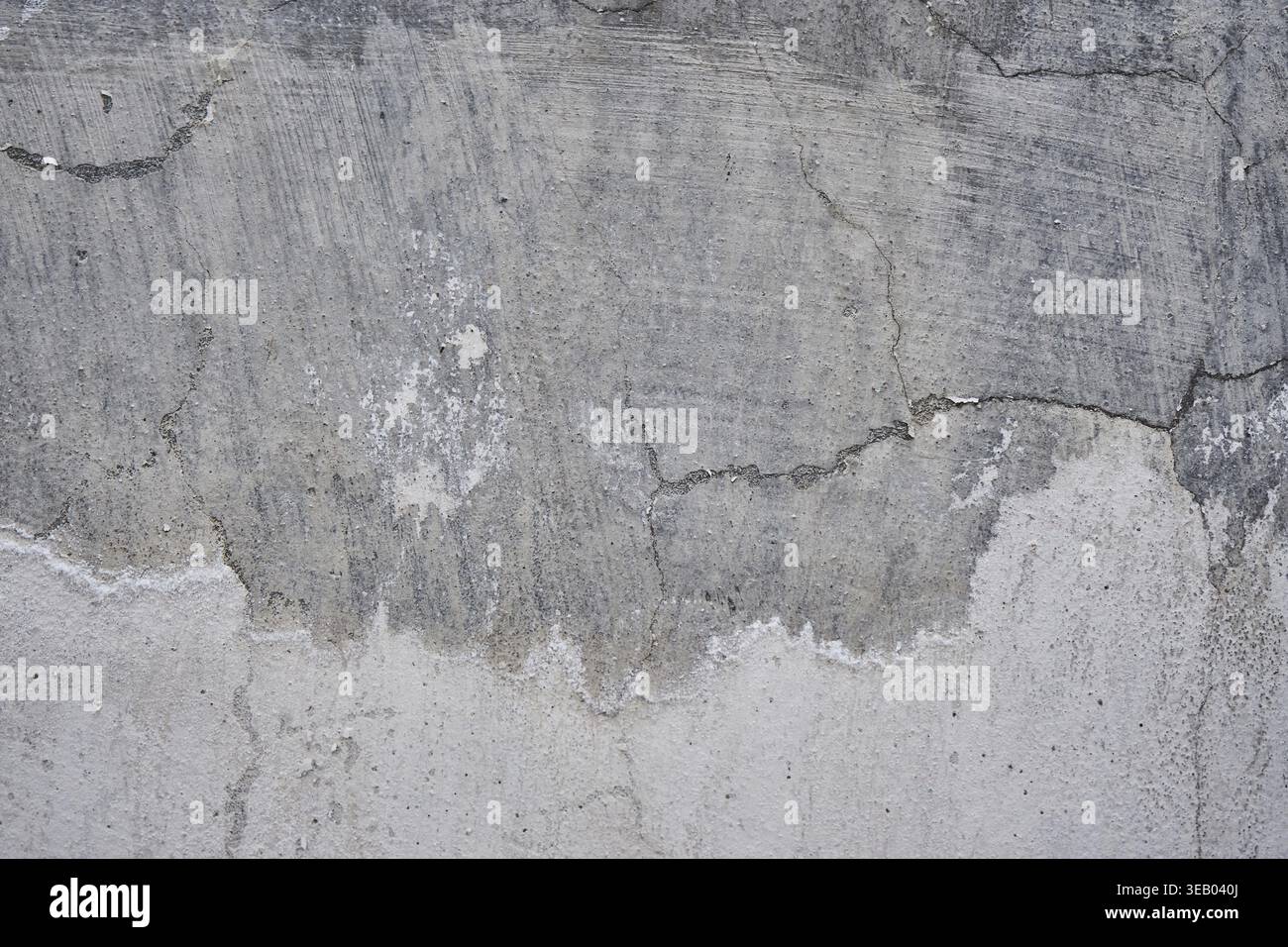 Concrete wall with crack, gray color background, removing plaster from a cement wall, rough surface texture. Renovation of old residential premises an Stock Photo