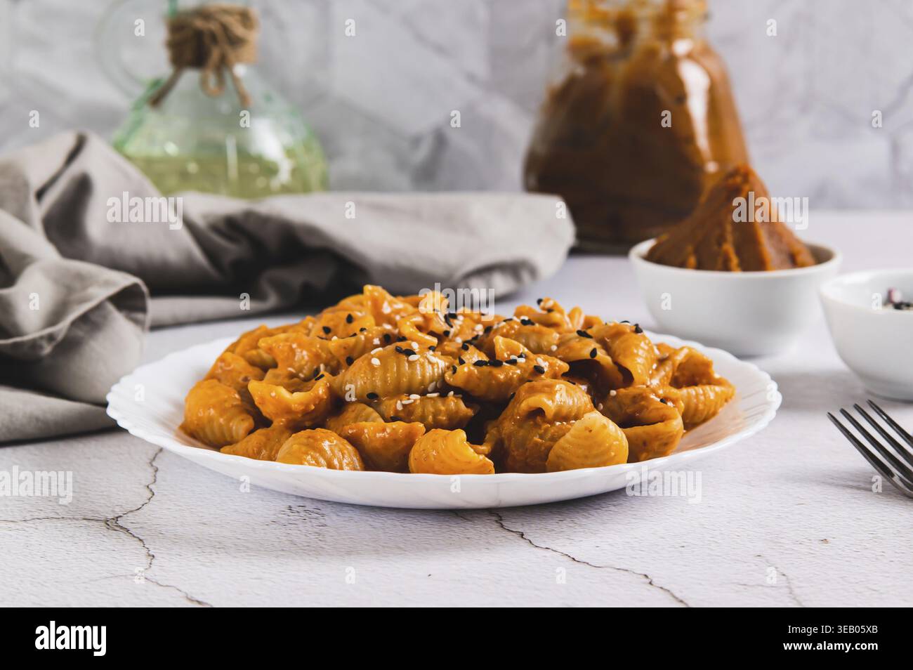 Spicy miso pasta shells on a plate on the table Stock Photo