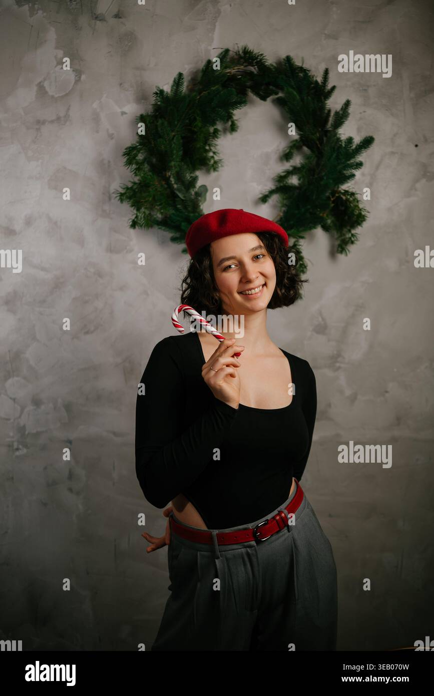 Joyful Woman with Candy Cane Wearing Red Beret Stock Photo