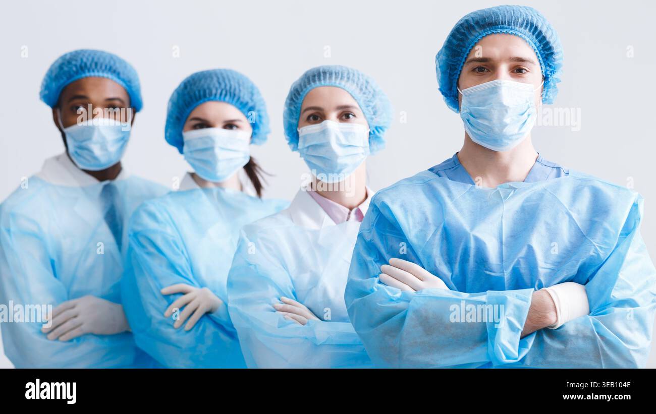 Surgeons Team. Doctors Wearing Protective Uniform, Look At Camera Stock Photo