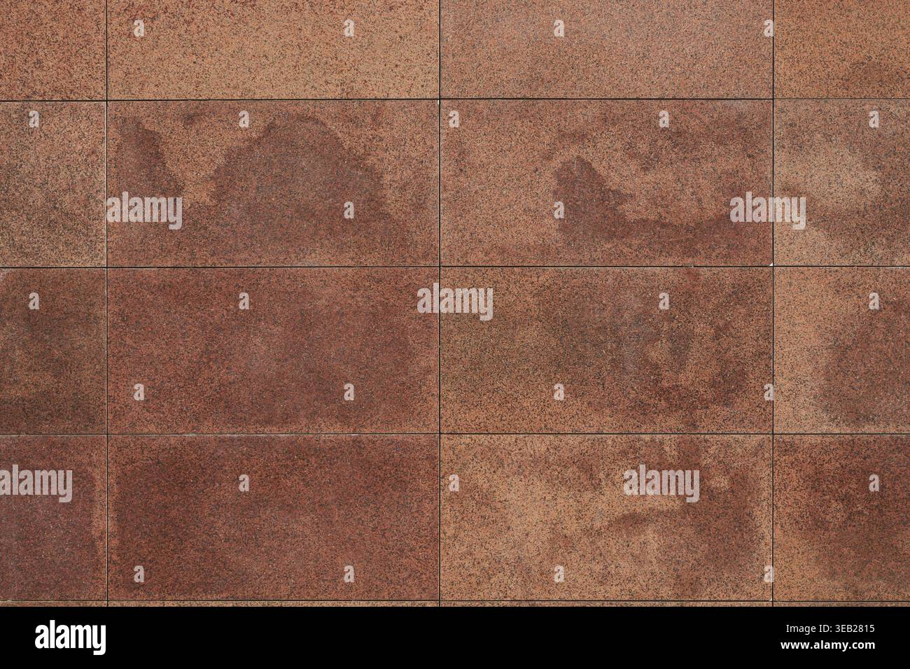 Granite tile wall, bricks, memorial cladding. Even rectangular red blocks, background. smooth surface of treated natural stone Stock Photo
