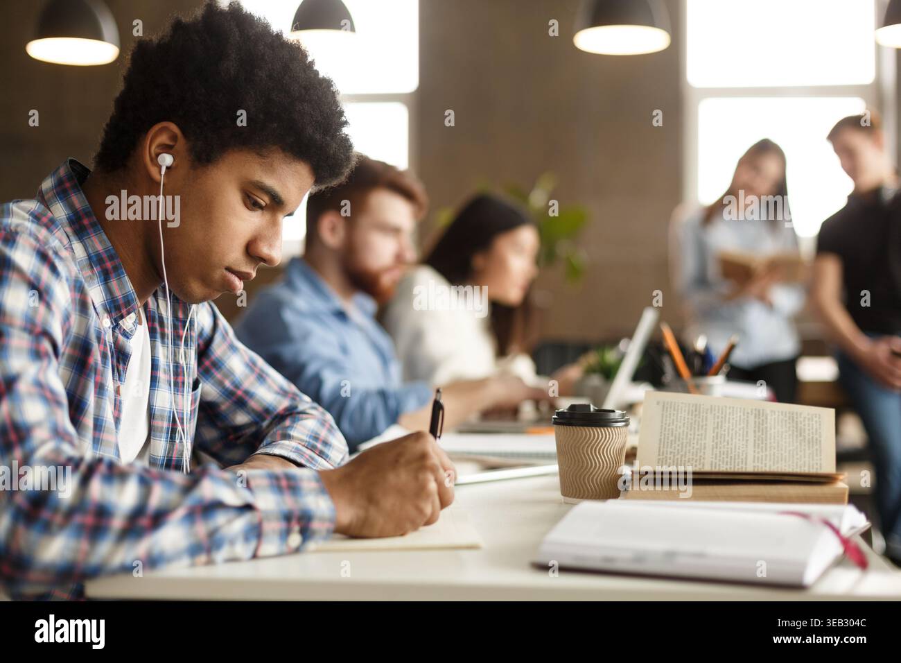 Student guy doing homework and preparing for exam Stock Photo
