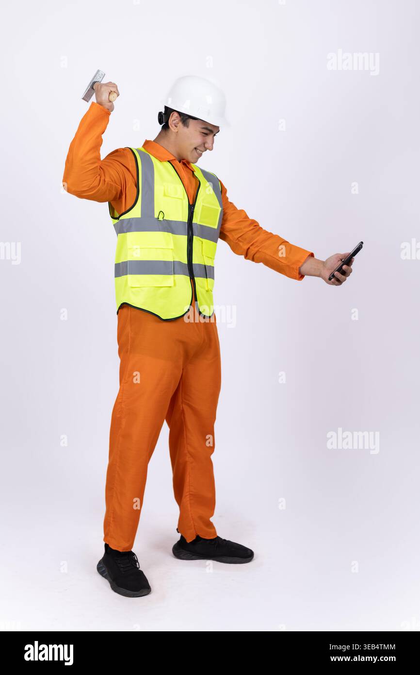 Construction worker in safety vest holding tools Stock Photo