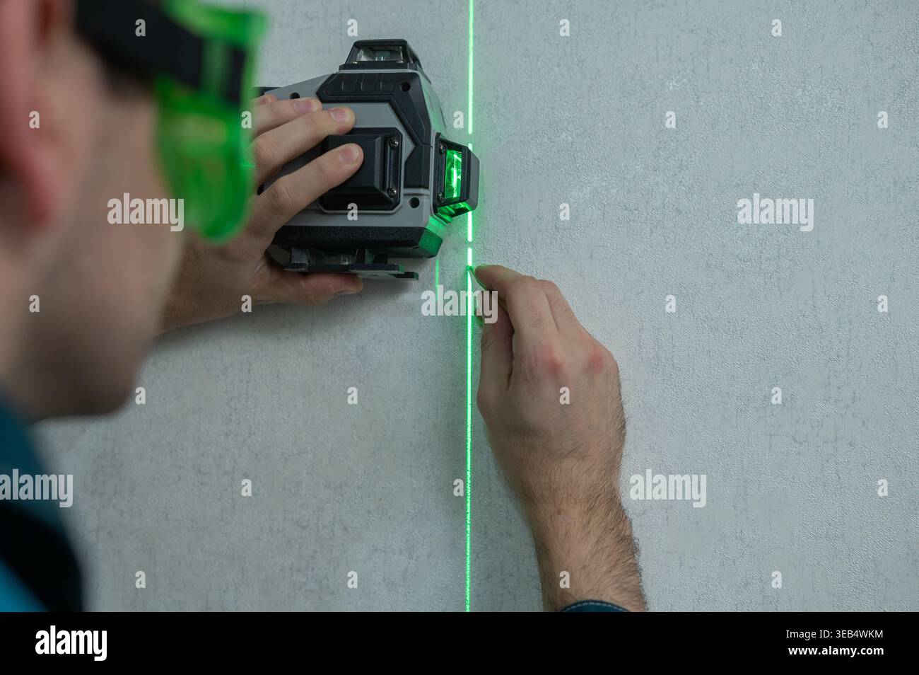 A man measures distance with a laser level.  Stock Photo