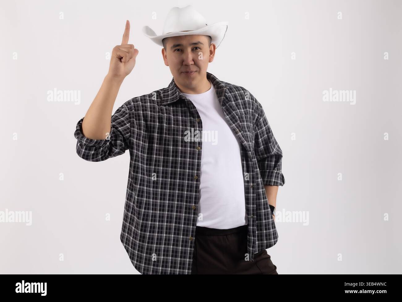 Man in a hat pointing upwards with a serious expression Stock Photo