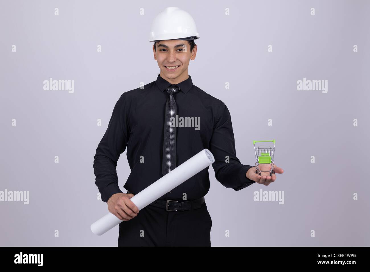 Engineer in hard hat holding blueprints and device Stock Photo